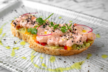 Bruschetta with tender cocktail shrimp, cucumber and radish in a festive plate on a marble background. Restaurant banquet menu.