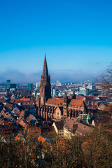 Obraz premium Germany, Freiburg im Breisgau cityscape, muenster cathedral in winter misty atmosphere, aerial panorama view above at sunset