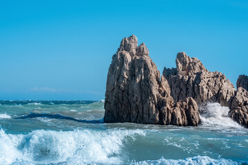 Fototapeta na wymiar sea coastal cliffs among surf on a windy sunny day
