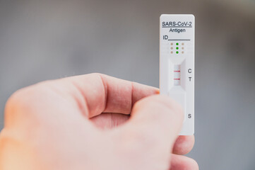 Hand holding positive covid rapid self test