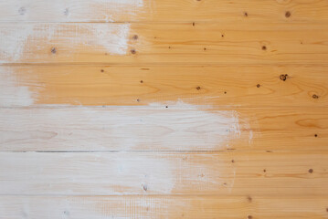 Half painted wall. Wooden wall being painted.