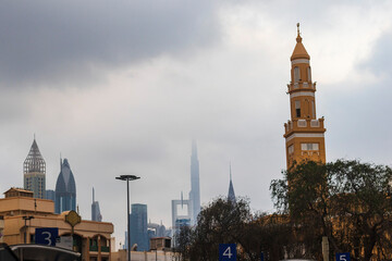 Fototapeta premium Dubai, UAE - 12.22.2021 - Shot of a minaret with cloudy sky on background in Satwa neighborhood. Streets