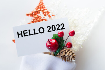 Hello 2022 on the card next to the new decoration on a white background