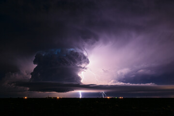 Supercell storm cloud illuminated by lightning