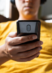 Unrecognizable man listening to cell phone music with headphones. Concept of the use of technology in everyday life.