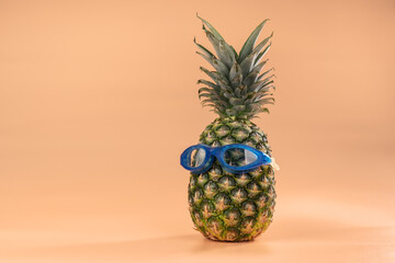 The interpretation of the pineapple fruit in a human image with goggles for swimming is a symbol of tourism recreation and vacations.