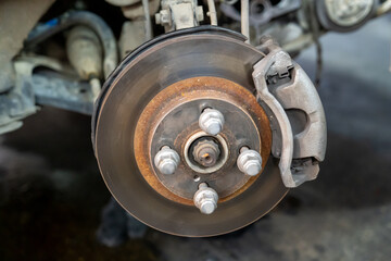 Vehicle's disc brake inspection and maintenance for repair in new tire changing process. Car brake repair in garage. close-up photo