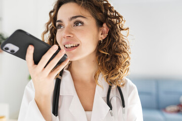 pretty woman doctor, sending audio note with her mobile phone