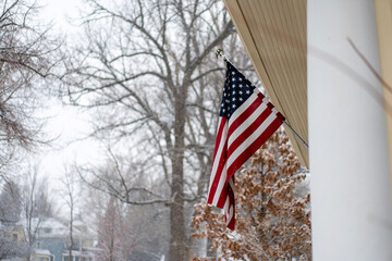 american flag outside the porch with winter snow in the background