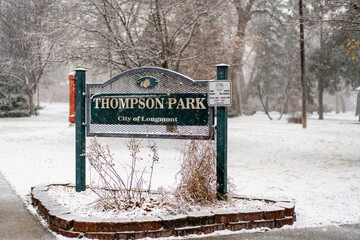Thomson Park sign in Longmont, Colorado, covered in first winter snow