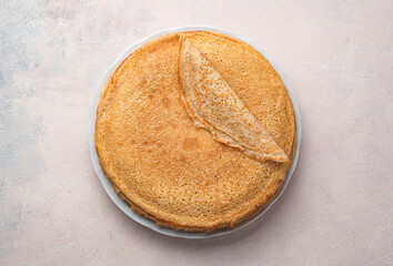 Traditional Russian blini on a light background. Fried pancakes in a stack on a plate. Carnival....