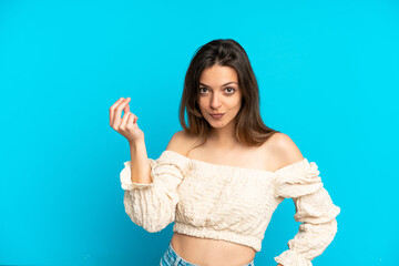 Young caucasian woman isolated on blue background making Italian gesture
