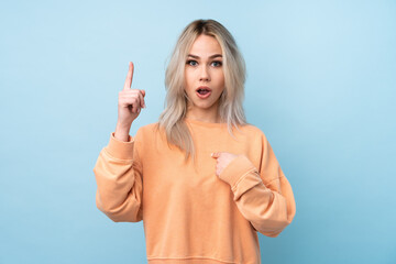 Teenager girl over isolated blue background with surprise facial expression