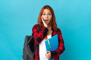 Teenager student Russian girl isolated on blue background with surprise and shocked facial expression
