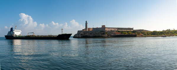 Panoramic photo of a ship with oil cargo entering the bay of Havana with the Morro castle...
