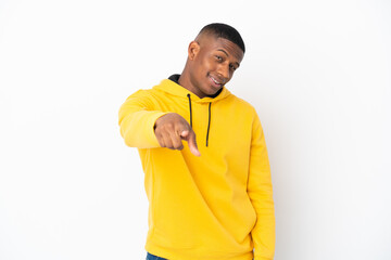 Young latin man isolated on white background pointing front with happy expression