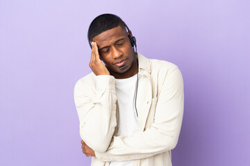 Telemarketer latin man working with a headset isolated on purple background with headache