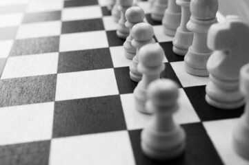 Chess pieces on wood board.Chess game. Set of chess pieces on the board. strategy games. Games for the development of intelligence. Blurred. Black-and-white.