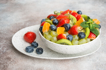 Fruit salad of blueberries, strawberries, grapes and kiwi in a plate