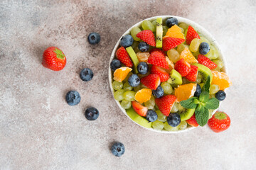 Fruit salad of blueberries, strawberries, grapes and kiwi in a plate, selective focus