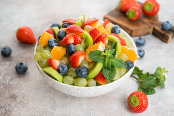 Fototapeta na wymiar Fruit salad of blueberries, strawberries, grapes and kiwi in a plate