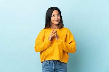 Caucasian girl isolated on blue background scheming something