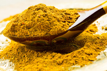 Curry powder in spoon close up