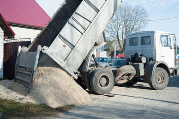 Trucks loaded with construction materials- fine grain sand, Transporting building