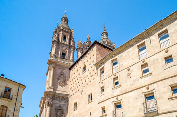 Fototapeta na wymiar Architecture in Salamanca, Spain; view of the Casa de las Conchas and a Baroque church in the background