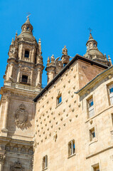 Fototapeta na wymiar Architecture in Salamanca, Spain; view of the Casa de las Conchas and a Baroque church in the background