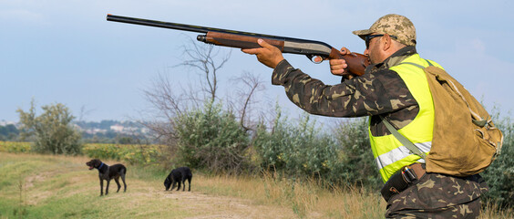 Hunter man in camouflage with a gun during the hunt in search of wild birds or game. Autumn hunting...