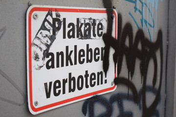 Plakate kleben verboten: verschmiert und mit Graffitis umringt