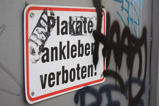 Plakate kleben verboten: verschmiert und mit Graffitis umringt