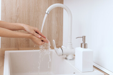 Washing hands under the flowing water tap. Hygiene concept hand detail. Washing hands rubbing with soap for corona virus prevention, hygiene to stop spreading corona virus in or public wash room.