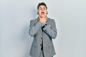 Young caucasian boy with ears dilation wearing business jacket shouting suffocate because painful strangle. health problem. asphyxiate and suicide concept.