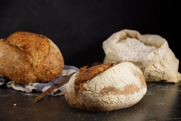 Artisan sourdough bread with tomato on a black marble table.