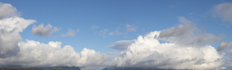 Panoramic View of Cloudscape during a cloudy blue sky sunny day. Taken on the West Coast of British Columbia, Canada.
