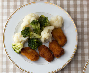 Dinner on a white plate that is on a dark background