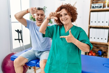 Fototapeta premium Physiotherapy woman working at pain recovery clinic with patient smiling making frame with hands and fingers with happy face. creativity and photography concept.