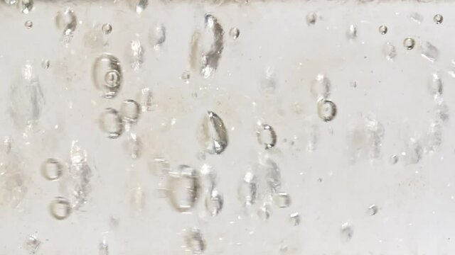 Macro shot of clear water air bubbling by pouring water inside clear pipette on white background. Slow motion. . High quality FullHD footage