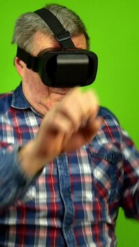 Mature adult man using virtual reality glasses.