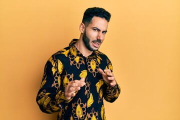 Young hispanic man wearing casual shirt disgusted expression, displeased and fearful doing disgust...