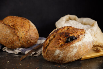 Artisan sourdough bread with tomato on a black marble table.