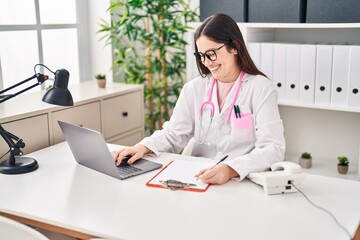 Young woman wearing doctor uniform working at clinic