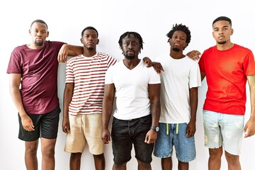 Young african group of friends standing together over isolated background relaxed with serious expression on face. simple and natural looking at the camera.