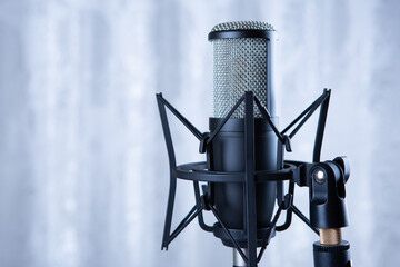 studio black condenser microphone against gray curtains