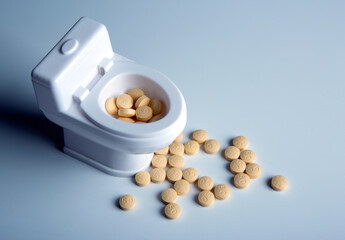 toilet bowl miniature and pills on the table