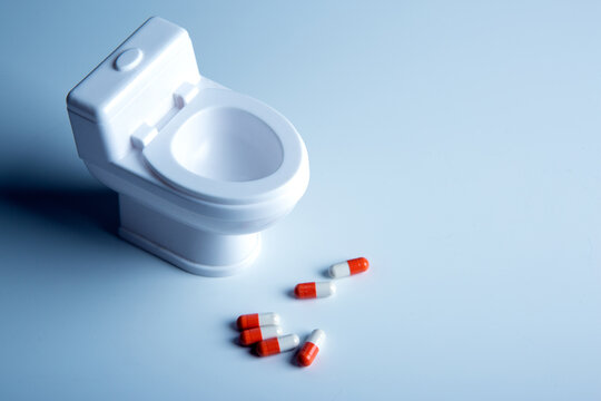 toilet bowl miniature and pills on the table