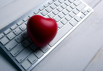 red heart on pc keyboard of notebook website close up
