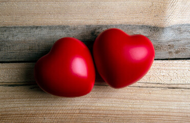 pair of red hearts on wooden background